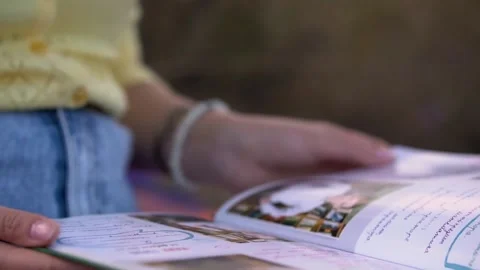 Henchka leafs through and examines a book with photographs. Stock Footage 161426257