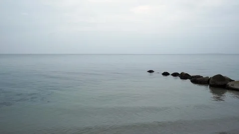 An hendheld shot of a rocks path in a calm winter sea. Stock Footage 86563175