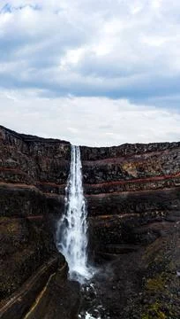 Hengifoss waterfall with deep red layers under cloudy sky Foto stock