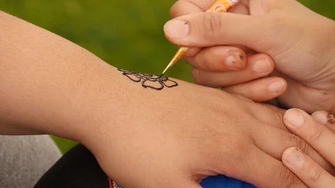 Henna tattoo is applied to a hand Stock Footage 112004045