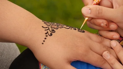 Henna tattoo is applied to a hand Stock Footage 112004203