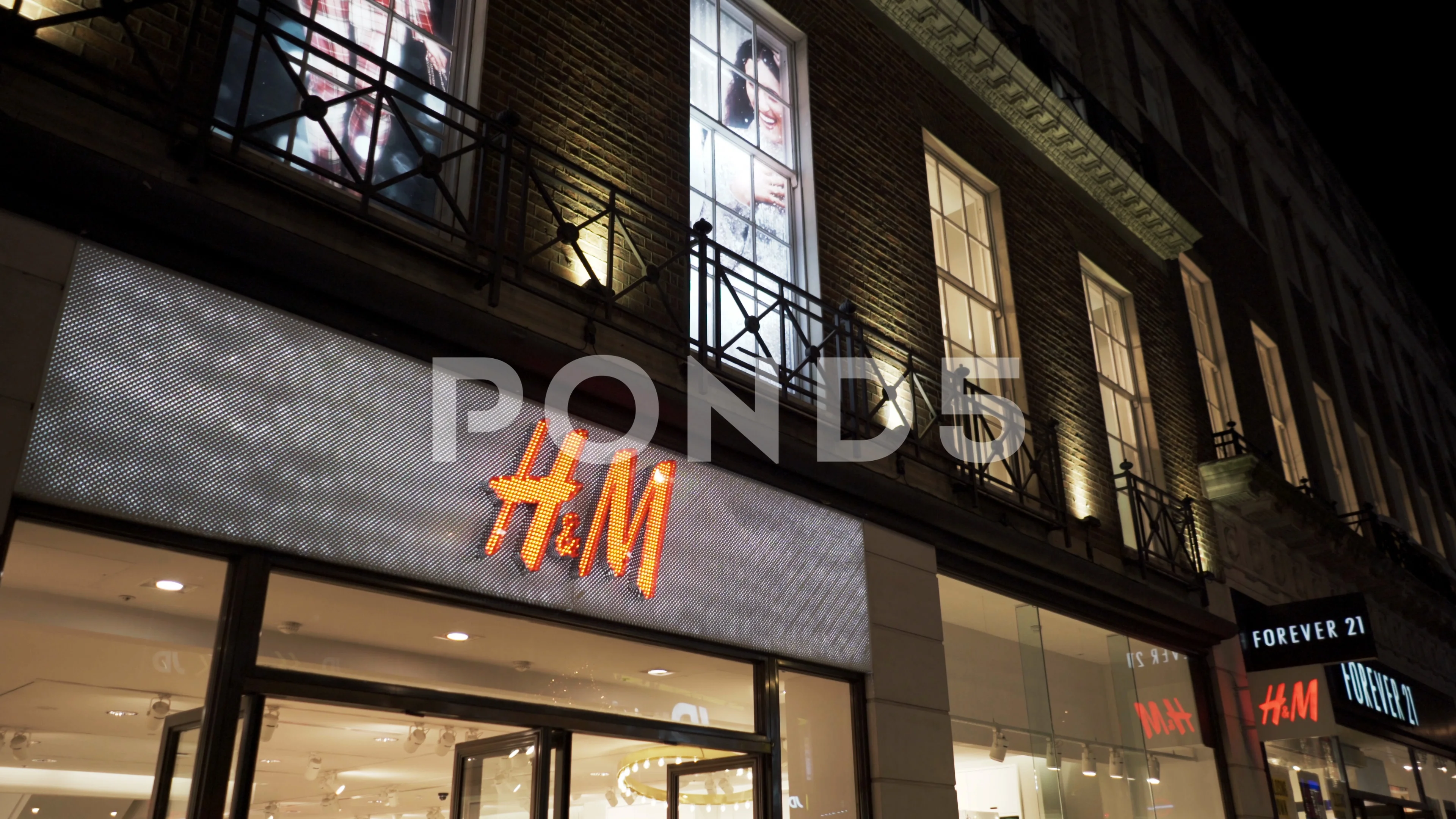 Hennes Mauritz brand store on Oxford street in central London at night. 4K