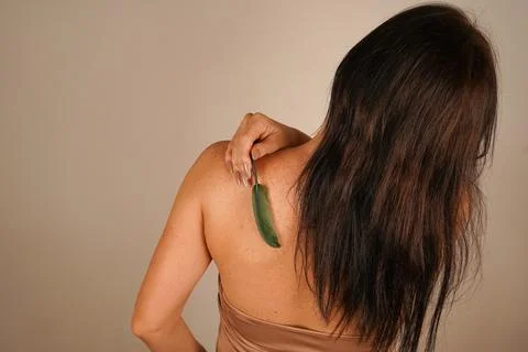 Her bare back radiates femininity, and the soft beige pastel wall gives a f.. Stock Photos