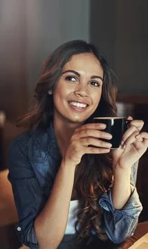 Her birthstone must be a coffee bean. a relaxed young woman enjoying a cup of Stock Photos