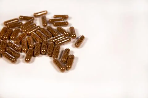 Herb capsule with Brown herbal leaf. Pills in a white background. Copy space Stock Photos