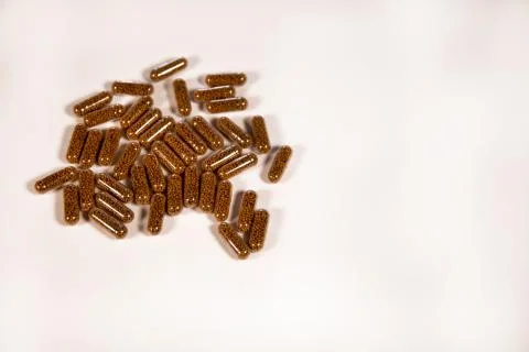 Herb capsule with Brown herbal leaf. Pills in a white background. Copy space Stock Photos