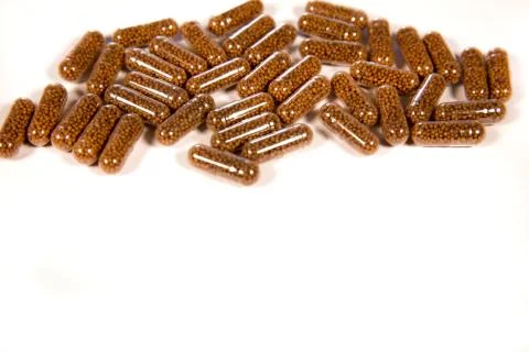 Herb capsule with Brown herbal leaf. Pills in a white background. Copy space Stock Photos