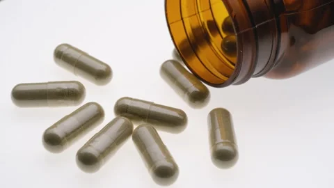 Herb capsule pill with brown bottle rotating on white background Stock Footage 170677174