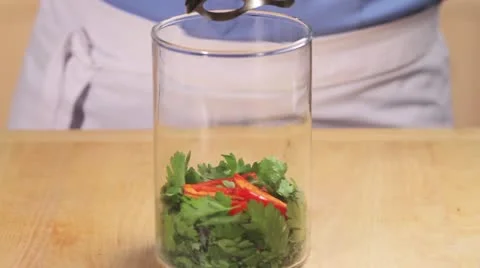 Herb sauce being made: ingredients being pureed with a hand blender Stock Footage 24671384