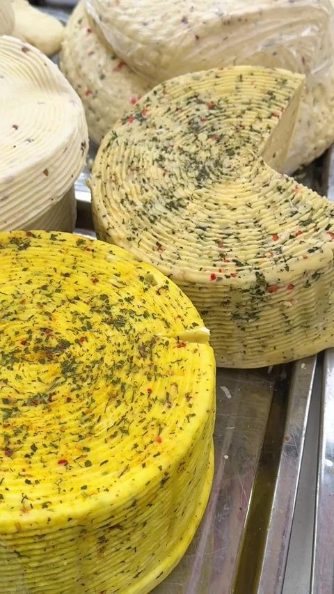 Herb-spiced cheese heads of cheese Many pieces of different types cheeses with Stock Footage 326464779