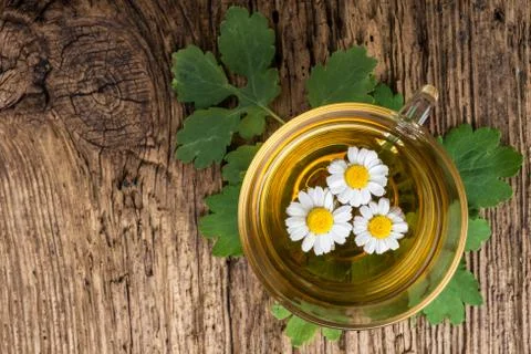 Herbal tea with chamomile on old wooden table. Top view. alternative medicine Photos