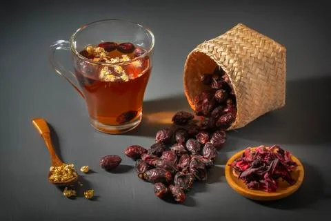 Herbal tea with medical chamomile and dried rosehips on a dark table Stock Photos