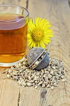 Herbal tea from the root of elecampane in a strainer with a mug Stock Photos