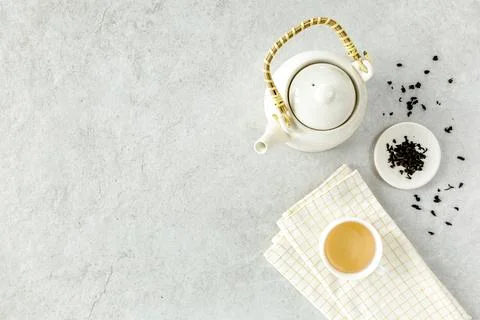 Herbal tea with two white tea cups and teapot, with green tea leaves. Flat lay Stock Photos