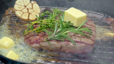 Herbcrusted steak with garlic, panseared beef accented with herbs and butter Stock Footage 325844822