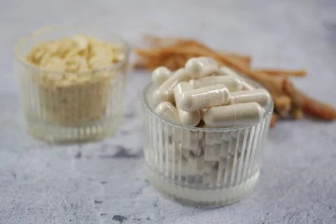 Herbs and capsules on a table with a gray background Stock Photos