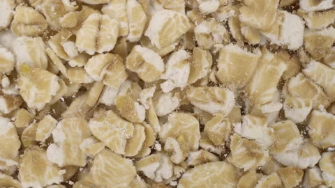 Hercules flakes fall on glass on a bright white background. Oatmeal bottom macro Stock-Footage 148495018