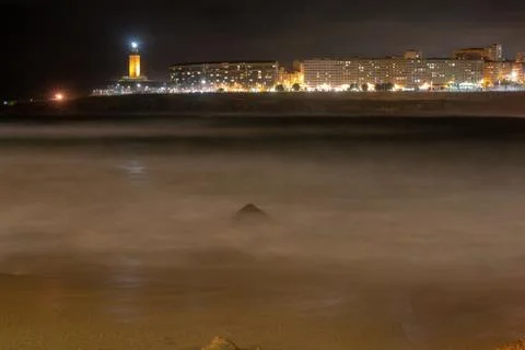 Hercules tower seen from the riazor beach with choppy sea Stock Photos