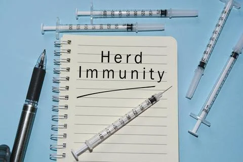 Herd Immunity text on white notepad with disposable injection syringes Stock Photos