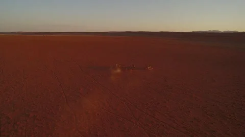 A herd of zebras are making their way through a red stone desert - Namibia Stock Footage 64939149