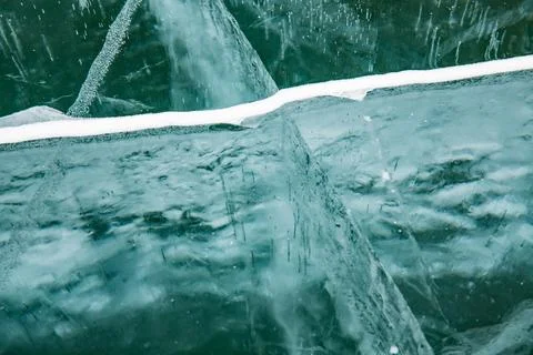 Here is a close up view of a clear piece of ice floating in the water Stock Photos