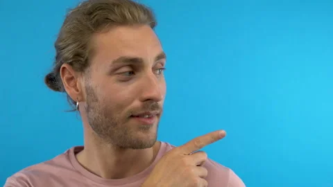 Here! Young fun guy 20s 30s years old in pink t-shirt isolated on blue Stock Footage 137972472