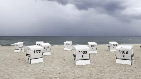 Heringsdorf: Dark rain clouds pass over an empty beach with beach chairs, 4K Stock Footage 280681366