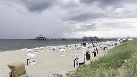 Heringsdorf: Dark rain clouds pass over an empty beach with beach chairs, 4K Stock Footage 280681367