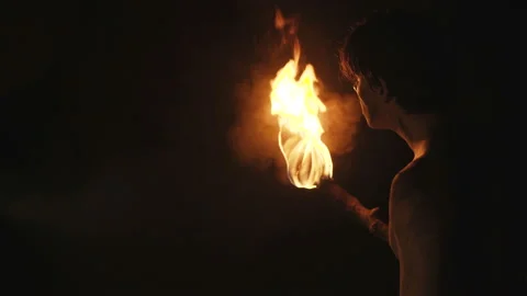 The hermit with burning torch walks and looks around in stone cave Video stock 88003537