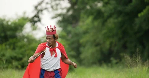 Hero man in red with crown walking and holding sword in the garden.  Stock Footage 201396087