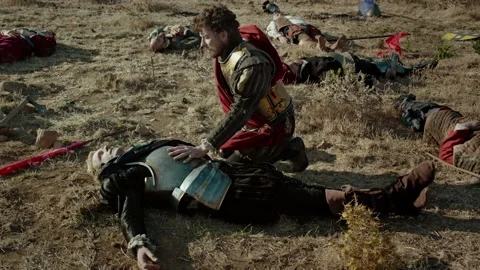 Heroes battle in open field during intense conflict near ruins at sunset Stock Footage 327944834