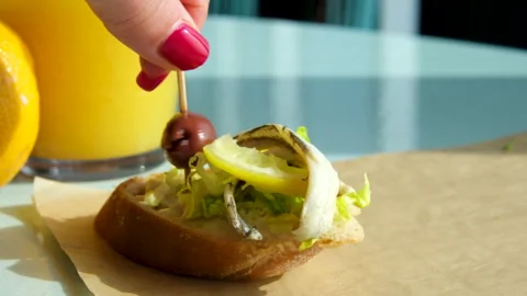 Herring and olive sandwich with a slice of lemon avocado orange juice morning Video stock 292134058