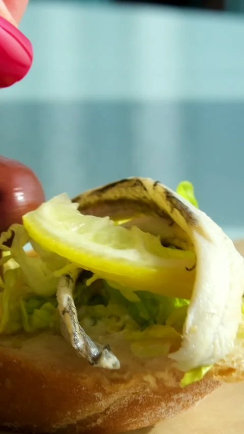 Herring and olive sandwich with a slice of lemon avocado orange juice morning Video stock 292314635