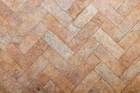 Herringbone pattern of natural stone tiles on the floor surface Stock Photos