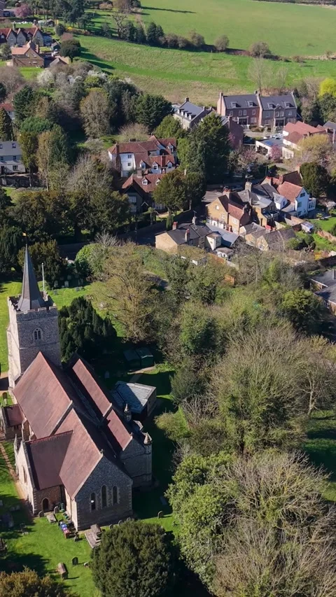 Hertingfordbury village vertical drone pullback showing church, rooftops, green Stock Footage 332902986