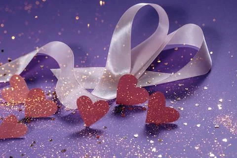 Herts with sequins on a violet background. Stock Photos