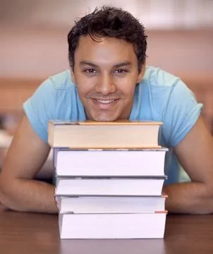 Hes eager to learn. Portrait of a young man sitting down and resting his head on Stock Photos