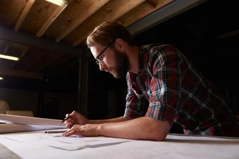 Hes an expert draftsman. a male architect drawing up building plans. Stock Photos