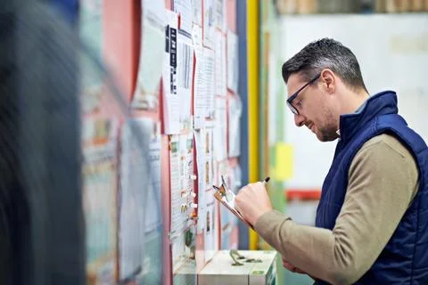 Hes fast and efficient. a man working in a large warehouse. Stock Photos