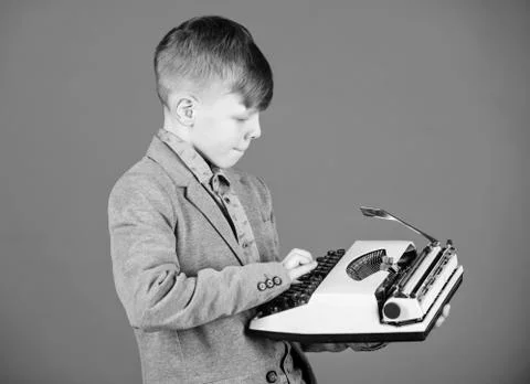 Hes going to write a composition. Smart child writer. Little writer typing on Stock Photos