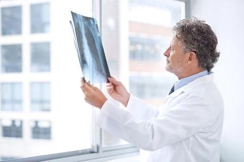 Hes got the inside information to your health. Shot of a mature doctor examining Stock Photos