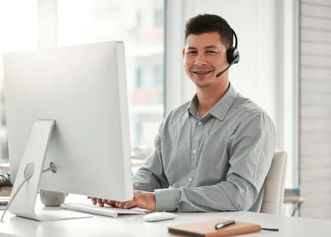 Hes got a passion for helping people. a young male call center agent using a Stock Photos
