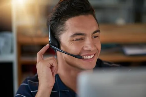 Hes the happiest when he solves customers problems. Shot of a young male agen Stockfoto's