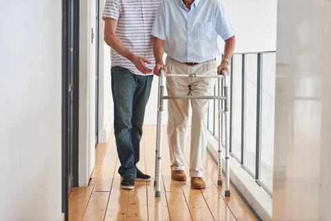 Hes making progress. a man assisting his elderly father with an orthopedic Foto stock