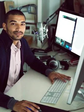 Hes a multitasking creative. Portrait of a focused young man sitting at a desk Stock Photos