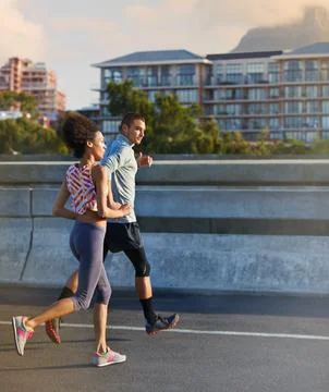 Hes setting a brisk pace. two friends jogging together through the city streets. Stock Photos