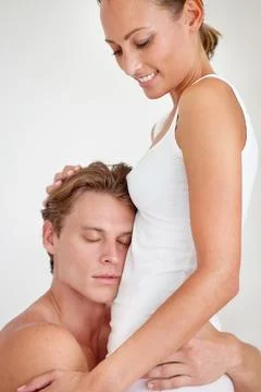 Hes such a devoted partner. a young man warmly embracing his girlfriends waist. Stock Photos