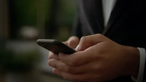 He’s texting Messages while standing near Modern Office Building. Wearing Stock-Footage 141253115