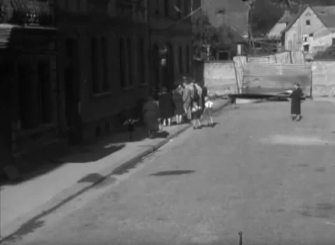 HESSE, GERMANY - 1946: Street queue - Women and children queue at a shopfront Stock Footage 344486013