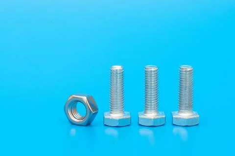 Hex bolt and nut on a blue background. Copy space for text. Stock Photos